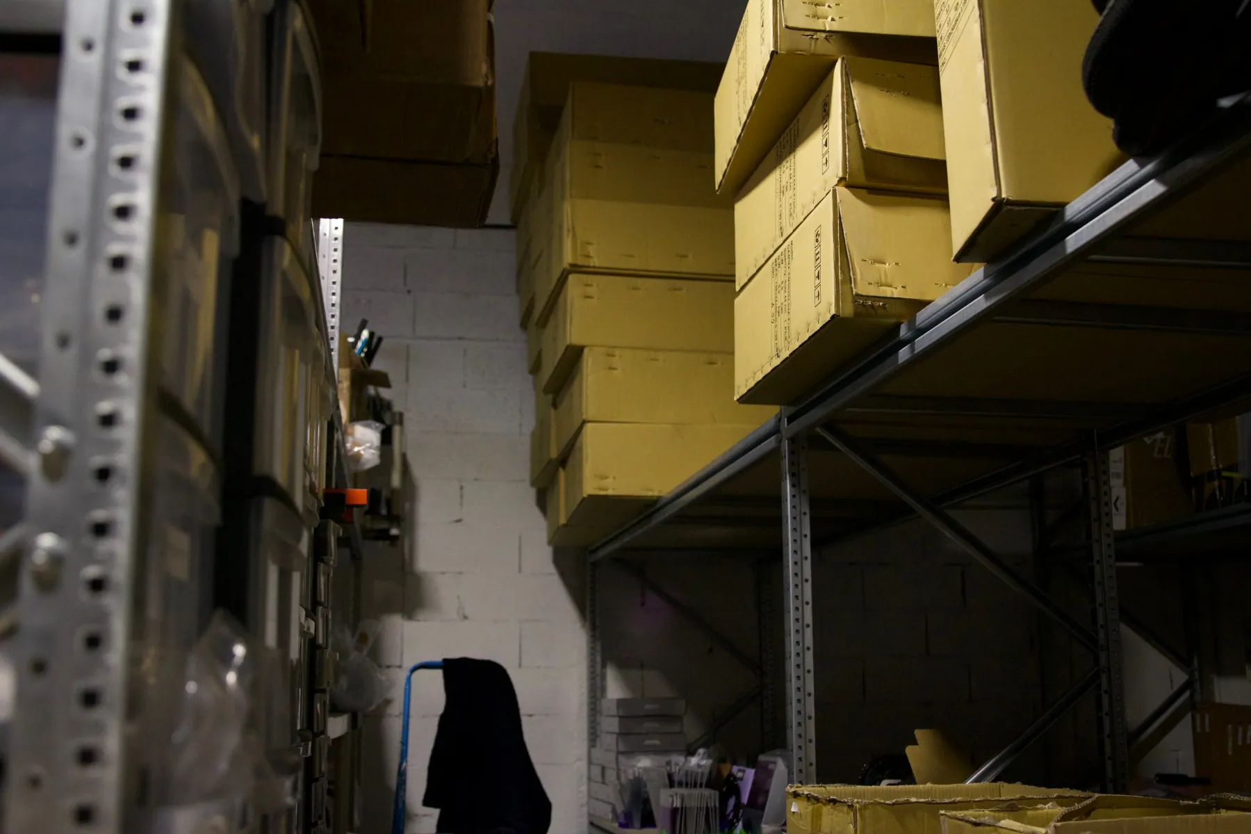 An aisle of the stock room, with boxed frames stacked on the shelves.